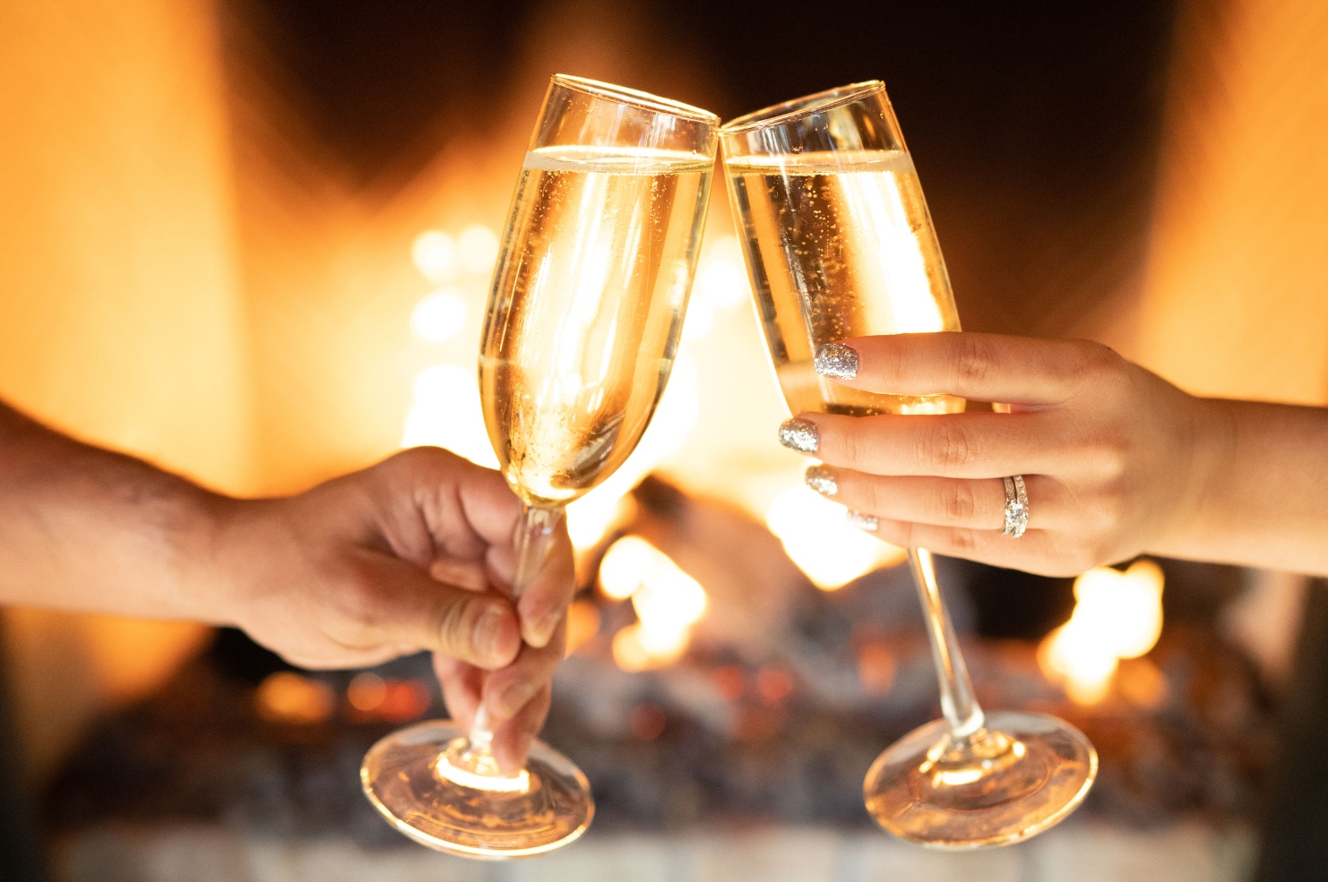 New Year's Eve cheers of champagne glasses in front of the fireplace in Harvest restaurant